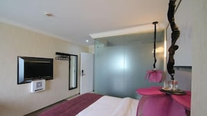 A hotel room with a bed, a television, a mirror, and a glass door leading to a bathroom. - Caozihua Boutique Hotel (Shanghai Pudong New International Expo Center/World Expo Area) (Shanghai)