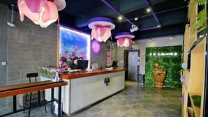 A reception area with a counter, bar stools, and decorative hanging lights. - Caozihua Boutique Hotel (Shanghai Pudong New International Expo Center/World Expo Area) (Shanghai)