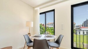 A dining area with a round table, four chairs, and a lamp.