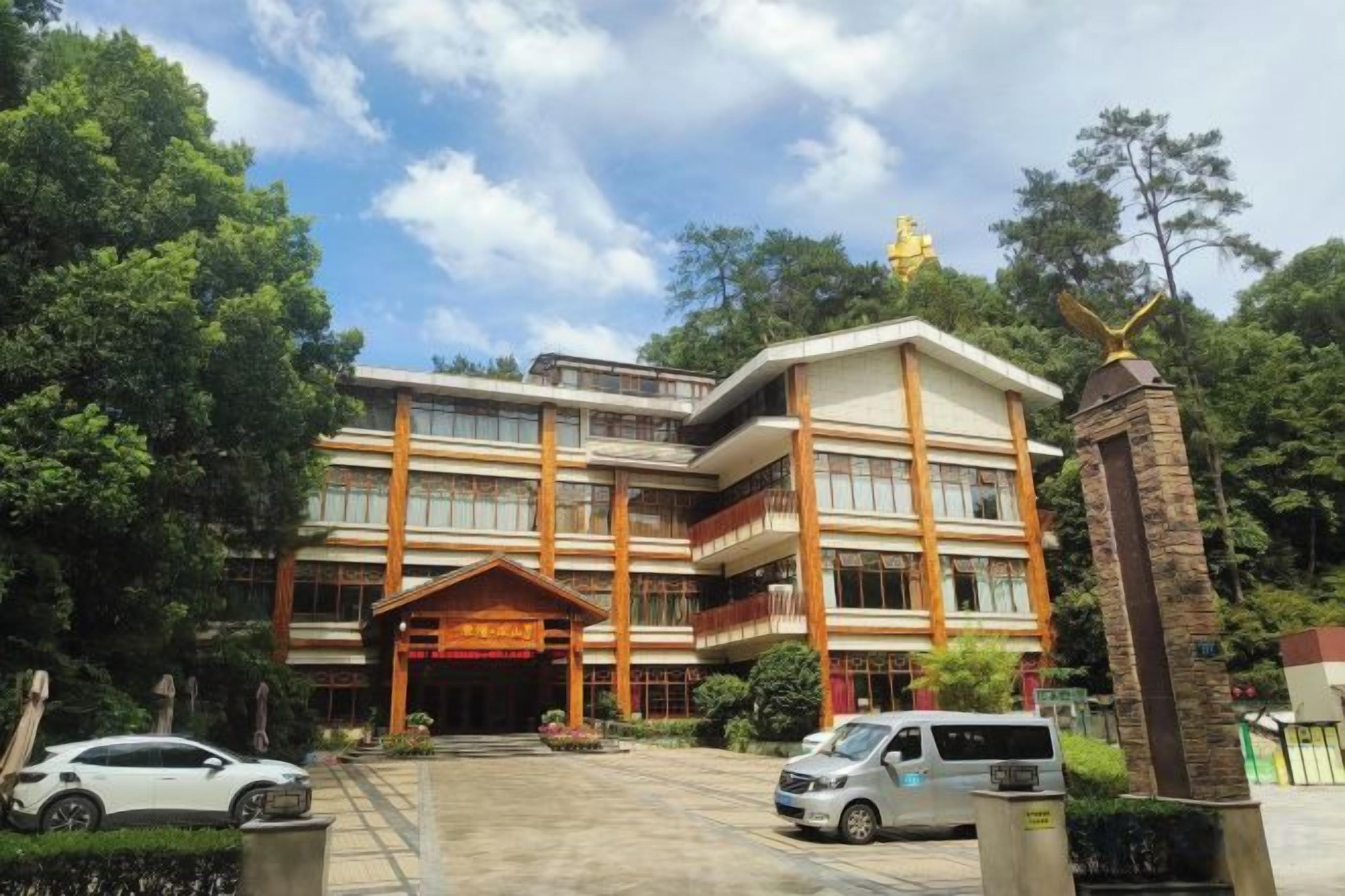 A multi-story building with a prominent entrance, surrounded by greenery.