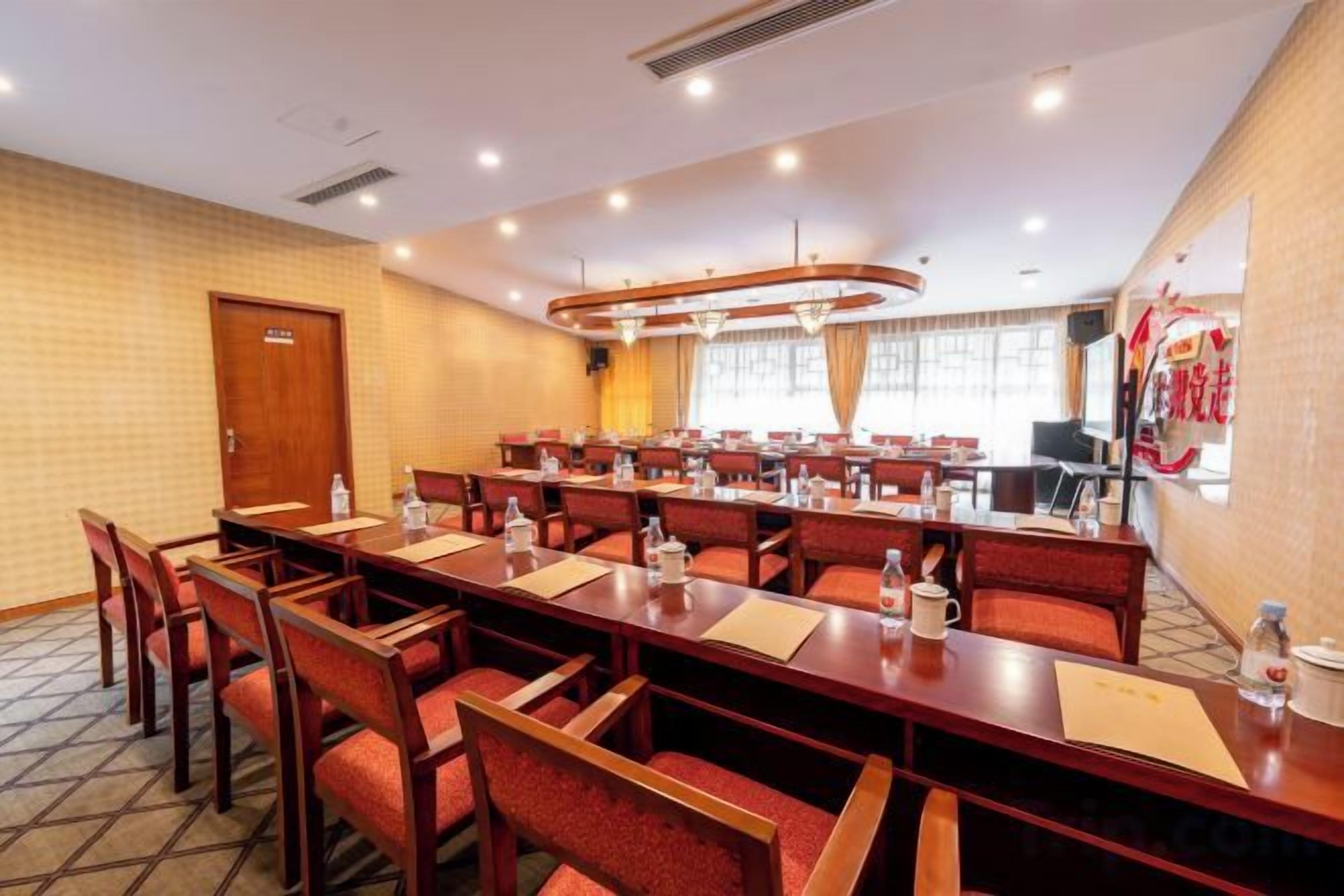 A conference room with multiple tables and chairs, equipped with water bottles and nameplates.