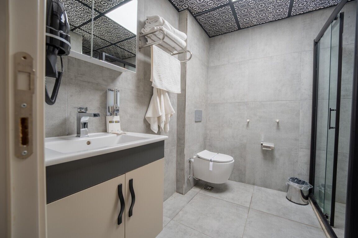 Un baño moderno con lavamanos, inodoro y cabina de ducha de vidrio.
