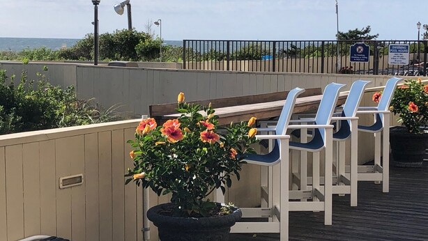 A deck with lounge chairs and a potted plant. - Oceanfront High Point North Studio M8 Just Steps to the Beach! (Ocean City)