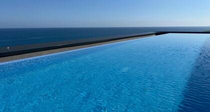 Appartement avec vue sur la mer et piscine à débordement, idéal pour les familles.