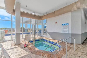 An indoor pool with a 3 FT depth, a spa rules sign, and a view of the outside.