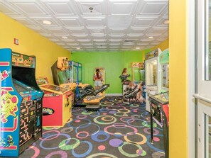 A brightly lit arcade with colorful machines and a green wall. - Luxe Oceanfront @ Seawatch Resort! (Horry County)