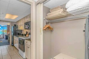 A kitchen with cabinets, a refrigerator, and a hanging rack. - Direct Oceanfront 1BR w/ lots of Pools! (Myrtle Beach)