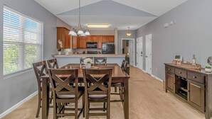 Une cuisine moderne avec des meubles en bois, un îlot central et des luminaires suspendus.