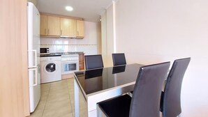 A compact kitchen with a washing machine, oven, and microwave.