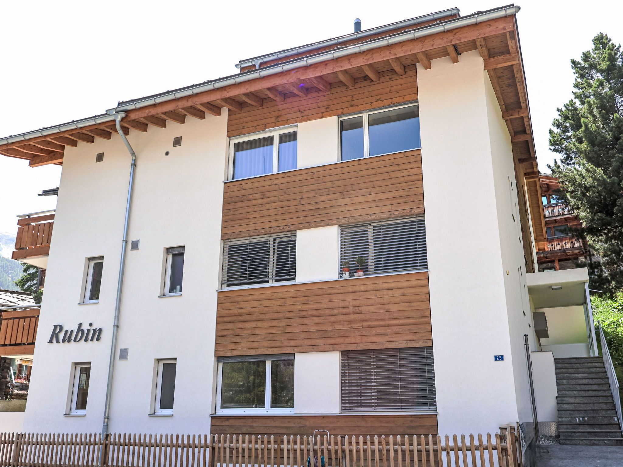 En byggnad med flera våningar, en träfasad och en skylt med texten ”Rubin”.