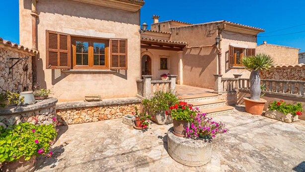 A traditional Mediterranean-style building with stone walls, wooden shutters, and terracotta roof tiles. - Nice home in Maria de la Salut (Maria de la Salut)