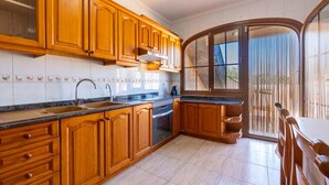 A kitchen with wooden cabinets, a sink, and a stove. - Nice home in Maria de la Salut (Maria de la Salut)