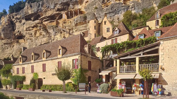 A stone building with a balcony and a sign that reads "ART DE CUISINE".