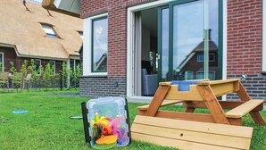 A modern house with a brick exterior, large windows, and a thatched roof. - 5 bedroom amazing home in Idskenhuizen (Idskenhuizen)
