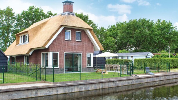 A house with a thatched roof, brick walls, and a large window. - 5 bedroom amazing home in Idskenhuizen (Idskenhuizen)