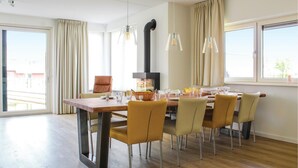 A dining area with a wooden table, chairs, and a black stove.