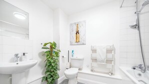 A modern bathroom with a sink, toilet, shower, and a potted plant. - Luxury Central London Balcony 1-Bed Apt w/ Parking (London)