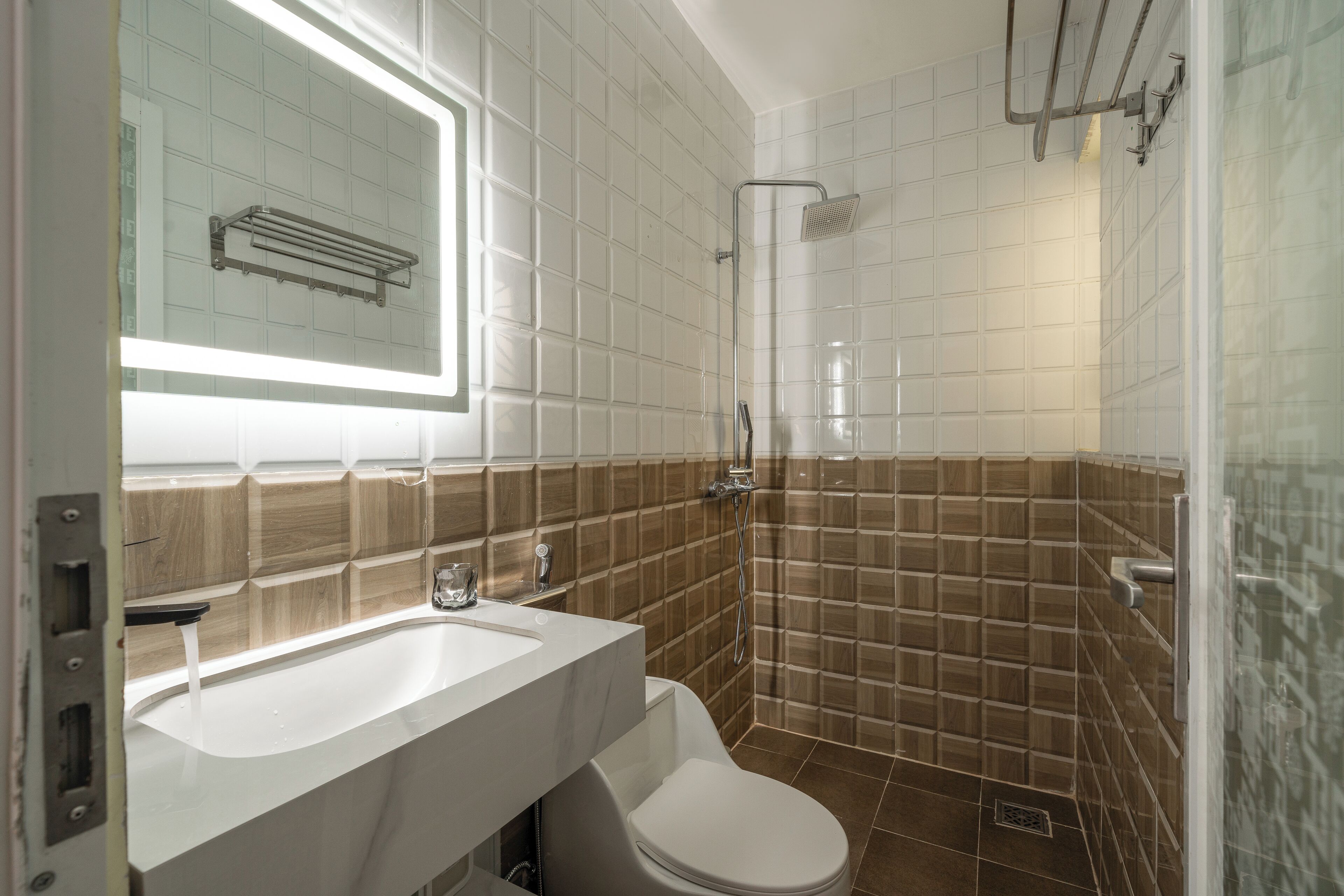 A modern bathroom with a white sink, a toilet, and a shower area.