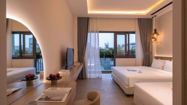 A modern hotel room with two beds, a TV, a dining area with a table and chairs, and large windows offering a city view. - The Cozy Inn Ho Chi Minh (Ho Chi Minh City)