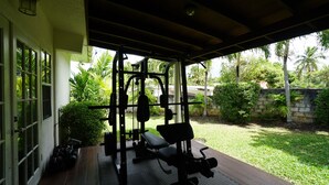 A covered outdoor gym area with exercise equipment, a bench, and a wall with greenery. - Designer Loft on Queen W | 10ft ceilings, parking (Toronto)