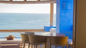 Una terraza con mesa y sillas con vista al mar.