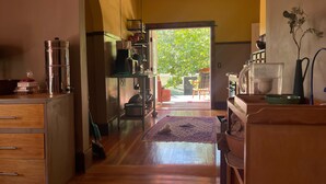A kitchen with wooden cabinets, a coffee machine, and a dining area with a table and chairs.
