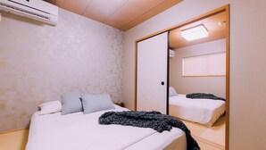 Un dormitorio con una cama, un espejo grande y un equipo de aire acondicionado.