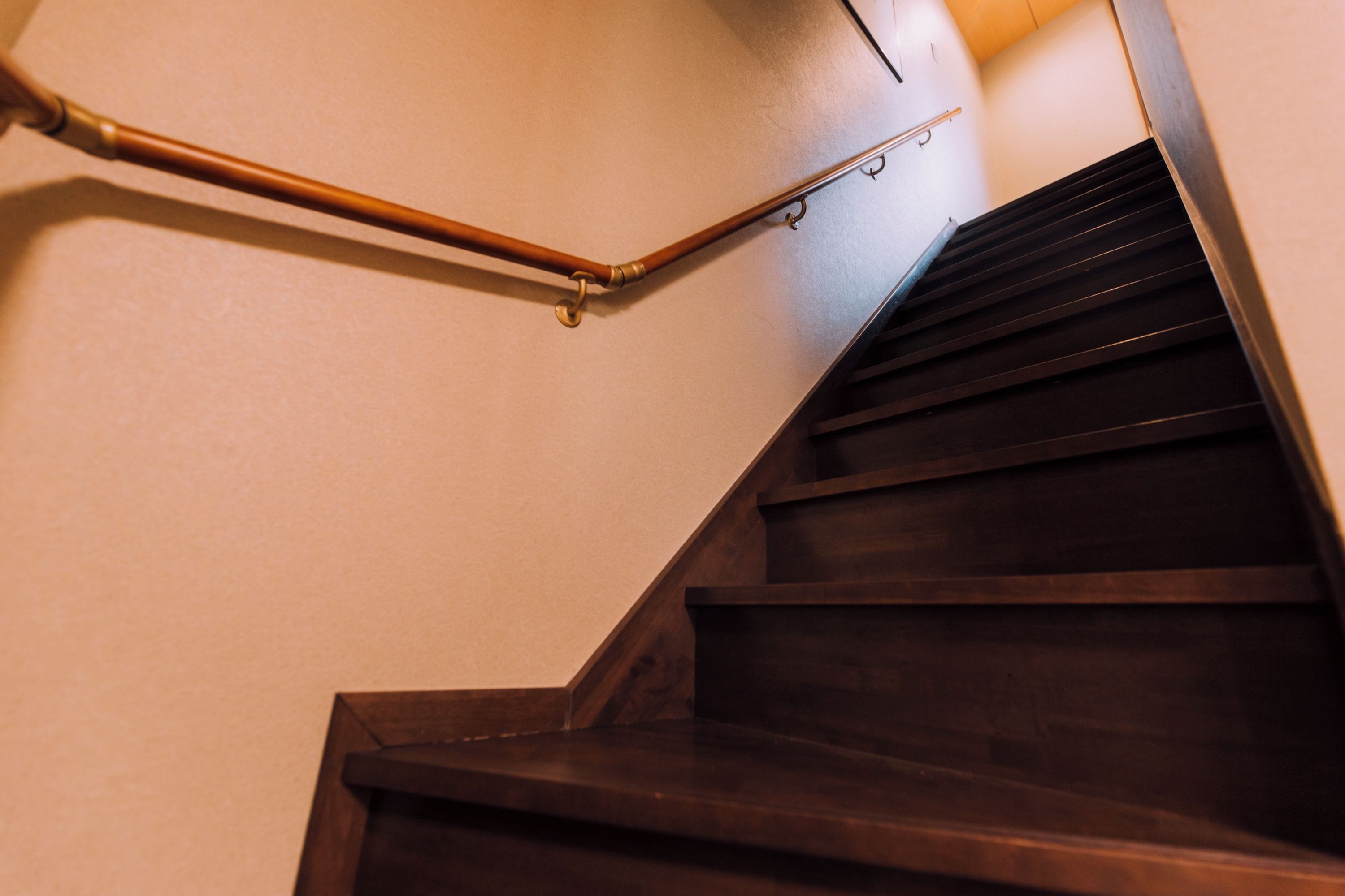 A wooden staircase with a handrail and a metal banister.