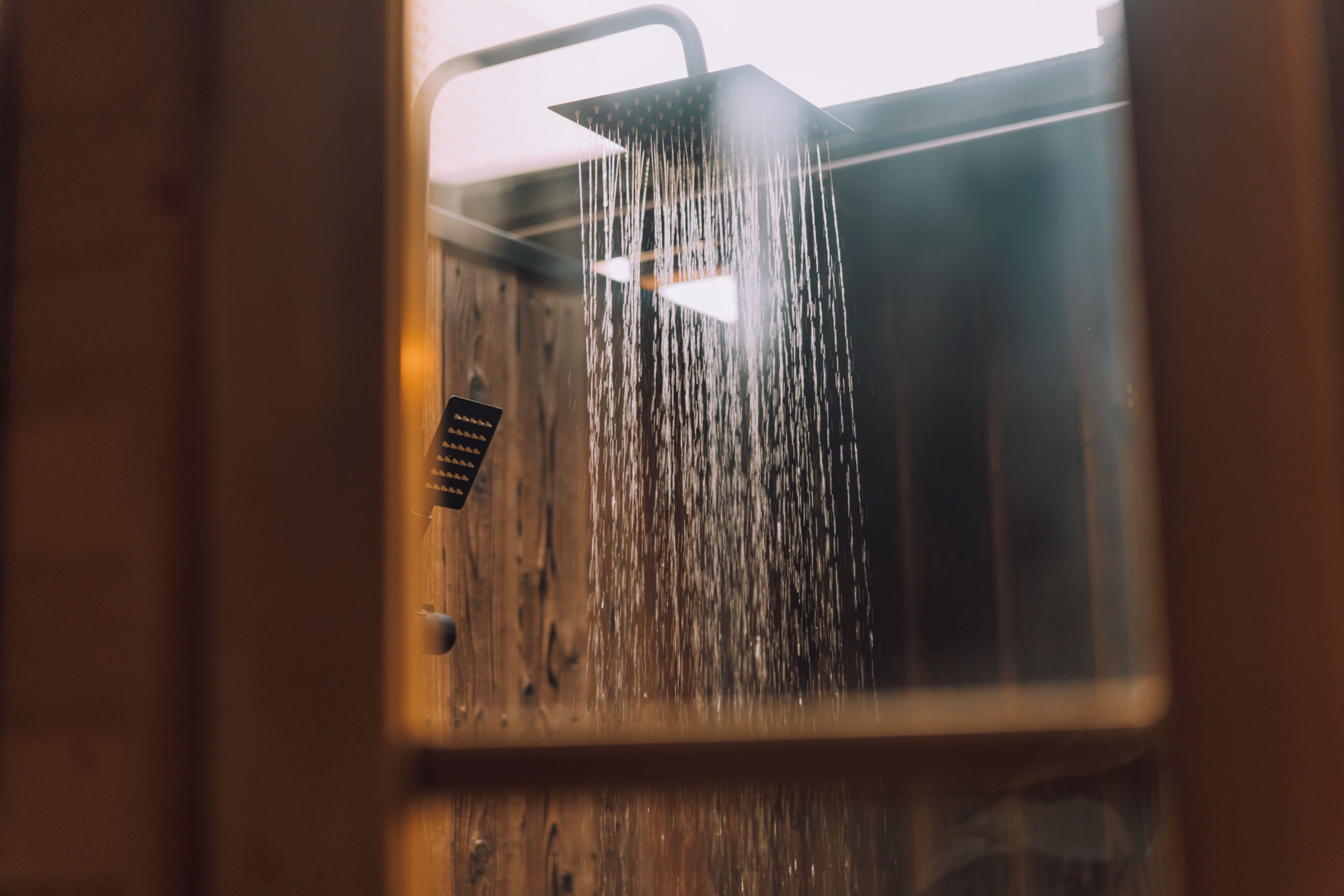 A shower with water flowing from a square head.