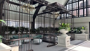 Un espacio interior moderno con techo alto, barandillas de metal y piso estampado.