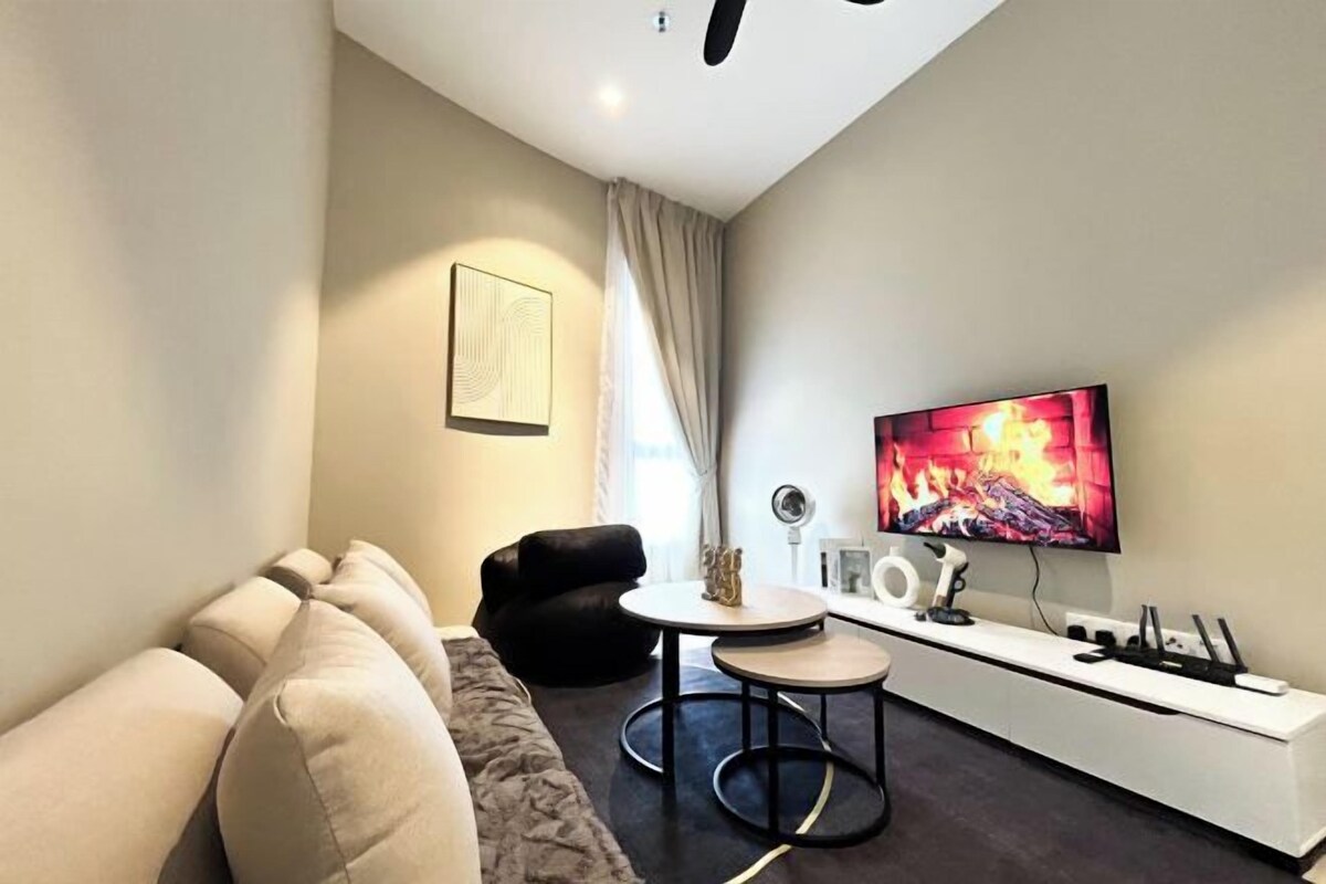 Uma sala de estar moderna com um sofá, uma mesa de centro e uma TV fixada na parede.