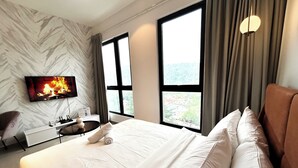 Habitación de hotel moderna con una cama grande, un televisor de pantalla plana, un escritorio y vistas al exterior.