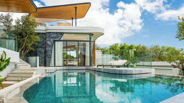 Une maison moderne dotée d’une piscine, d’une façade en verre et d’une terrasse en bois.