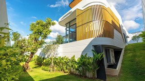 Une maison moderne au design épuré, dotée de grandes fenêtres et d’un jardin bien entretenu.