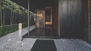 A modern interior with a dark wooden wall, a bamboo plant, and a tiled floor.