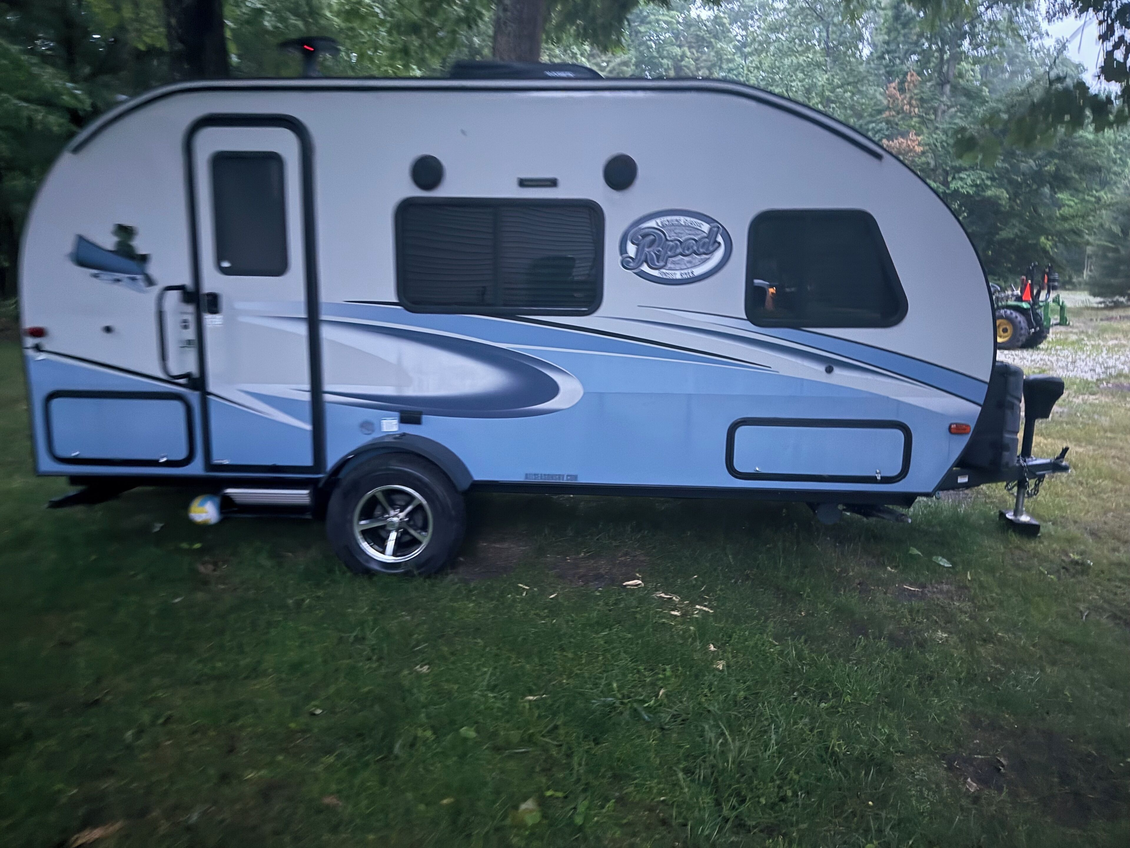 Een camper geparkeerd op een grasveld.