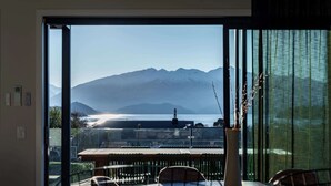 A room with a large window offering a view of mountains and a body of water. - Tiro Nui in the Heart of Wanaka (Wānaka)