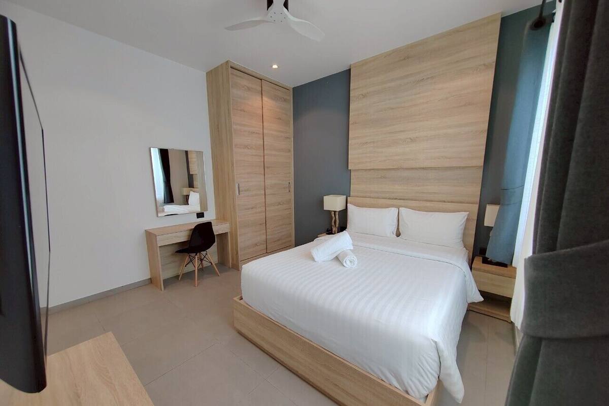 Un dormitorio moderno con una cama grande, un escritorio y un armario.