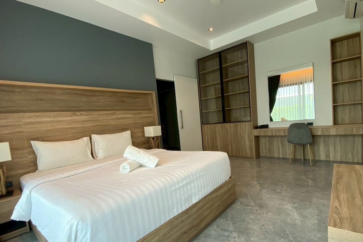 Un dormitorio moderno con una cama grande, un escritorio y estanterías empotradas.