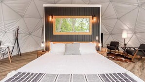 A tented room with a bed, a window with a view, and a chair. - Cozy Chalet & Luxe Domes Retreat w/Stunning Views (Augusta)