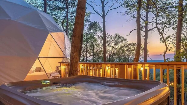 A hot tub on a balcony with a tent in the background. - Cozy Chalet & Luxe Domes Retreat w/Stunning Views (Augusta)