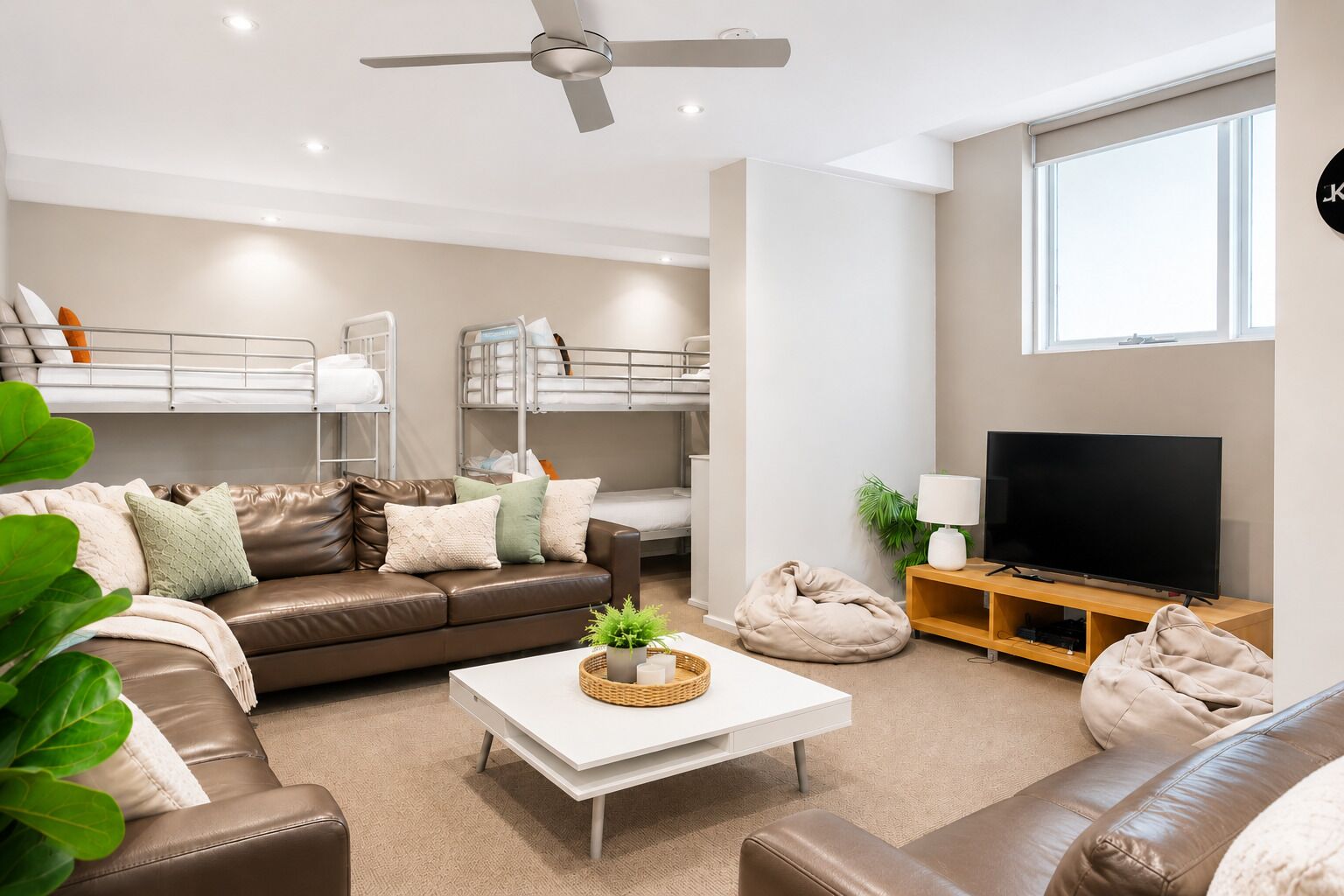 A modern living room with a sofa, coffee table, TV, and bunk beds.