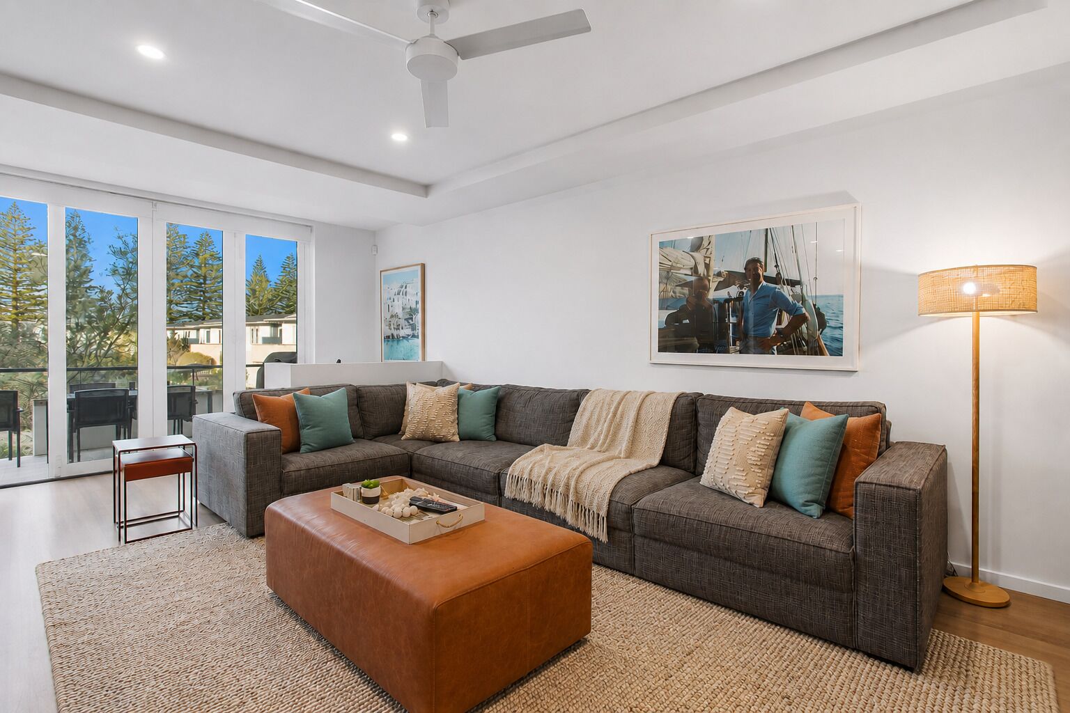 A modern living room with a sectional sofa, a coffee table, and a floor lamp.