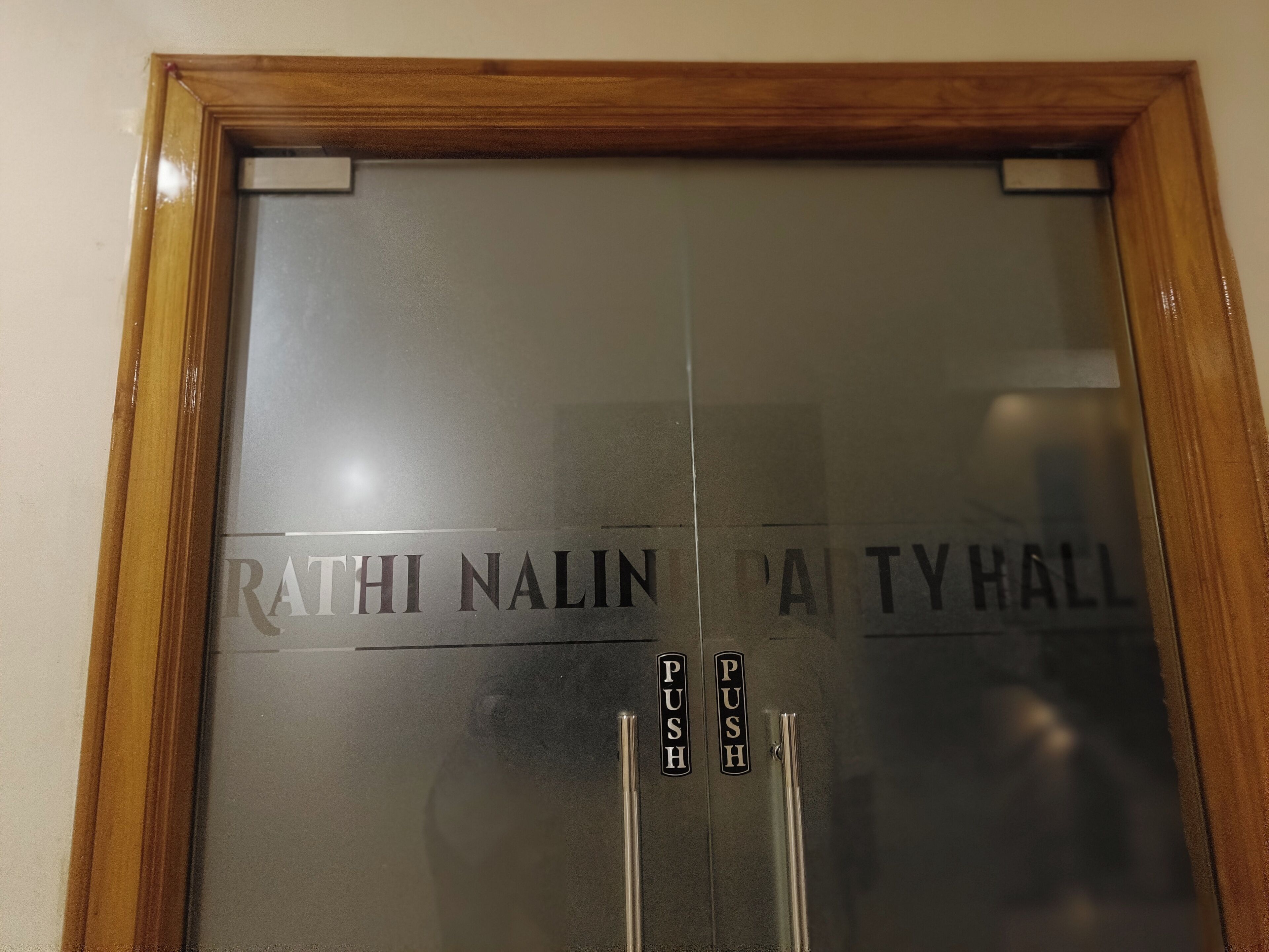 A door with the text "RATHI NALINI PARTY HALL" and two push buttons.