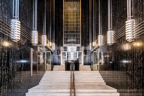 Eine prachtvolle Lobby mit Marmorwänden, einer zentralen Treppe und einer großen Uhr.