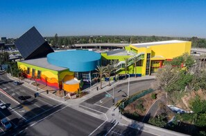 Un bâtiment moderne à la façade colorée, doté d’un grand toit bleu et d’un parking situé à l’avant.