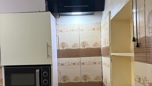 Cuina compacta amb microones integrat, fogó a gas i microones negre penjant.