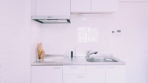 Eine moderne Küche mit weißen Schränken, einer Edelstahlspüle und einem eingebauten Backofen.