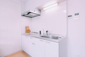 A modern kitchen with white cabinetry, stainless steel appliances, and a built-in oven. - moof Tsuruhashi - Dog-Friendly Stay & Roof Terrace (Osaka)