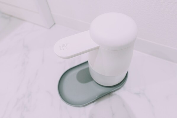 A toilet with a white flush handle and a foot pedal.